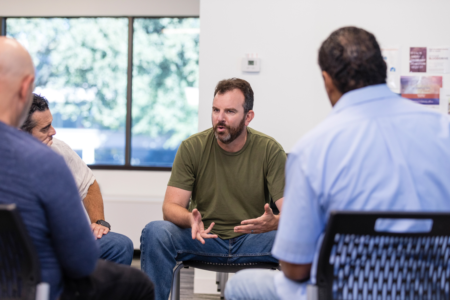 Man sat down talking in a group